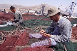 Image du Maroc Professionnelle de  Quelques ouvriers s'activent à réparer les filets de pêche sur un des quais au port d'Agadir, ville située au sud du Maroc, Vendredi 23 Août 2002. (Photo / Abdeljalil Bounhar)

 